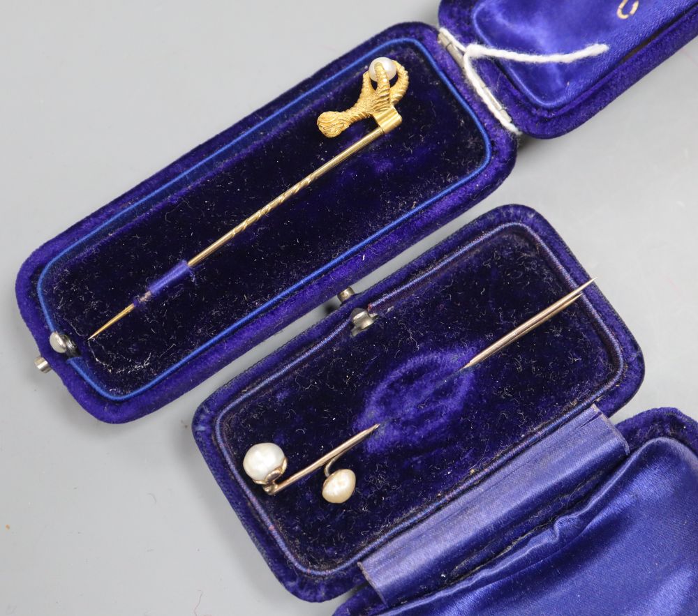 A Victorian yellow metal claw and natural saltwater pearl set stick pin, 68mm and two others.